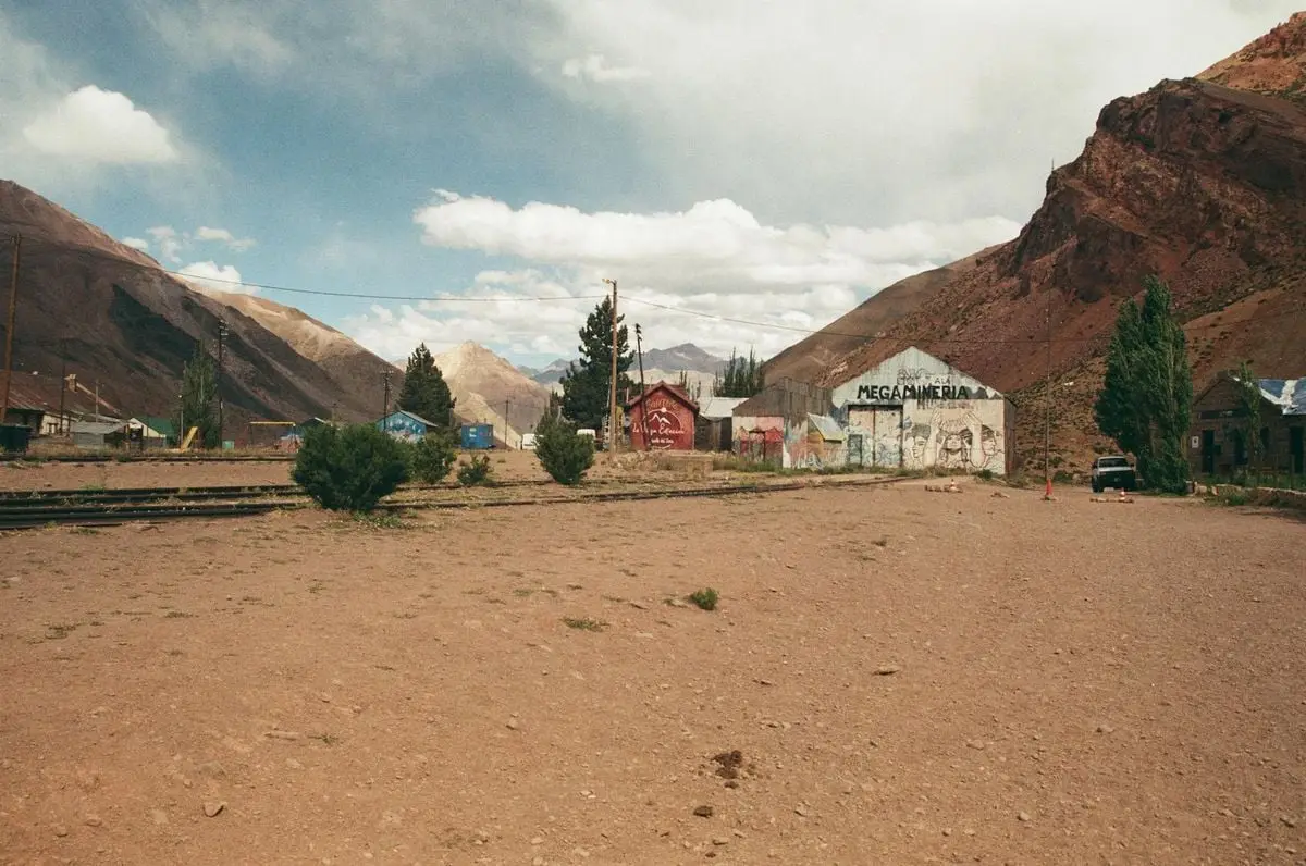Scenic view of a rural village with mountains and deserted train track.