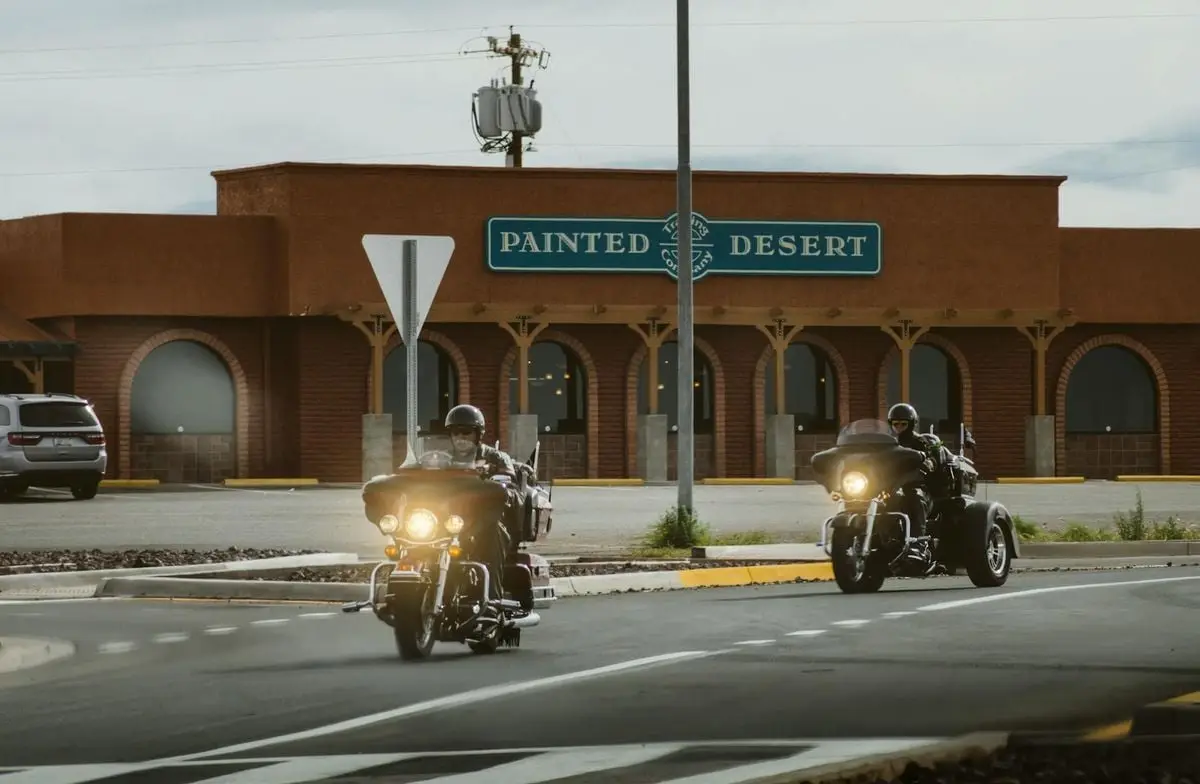 Bikers on a road trip riding through Young, Arizona past the Painted Desert building.