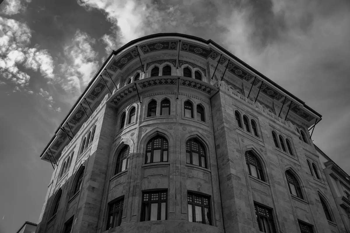Low angle black and white photo of an ornate historic building in Istanbul, highlighting architectural details.
