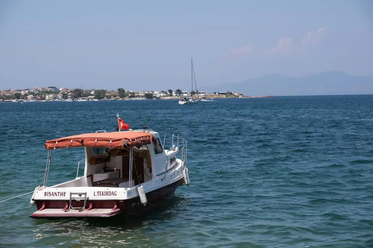 A picturesque view of a boat anchored in the calm waters of Foça, İzmir, Türkiye.