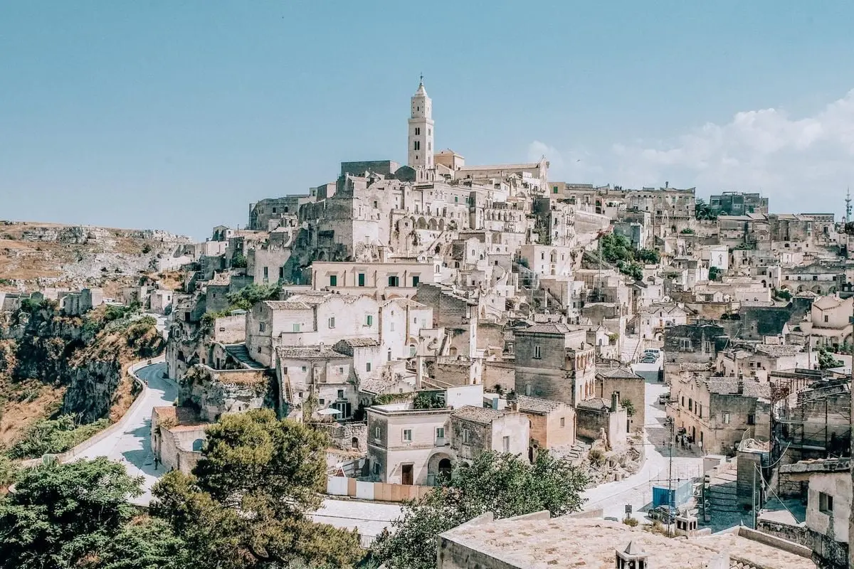 Scenic view of Matera's ancient town with historic architecture under a clear summer sky.