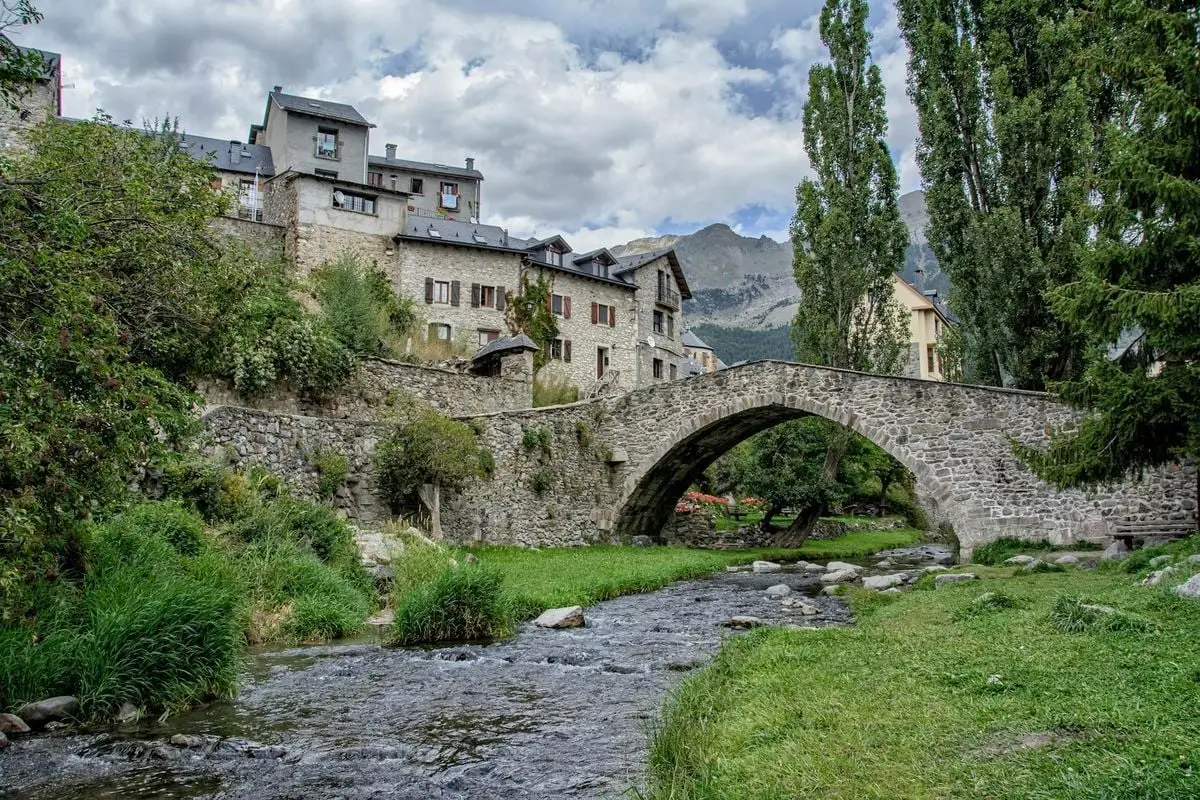 Charming medieval stone bridge over a river in Sallent de Gállego, Spain.