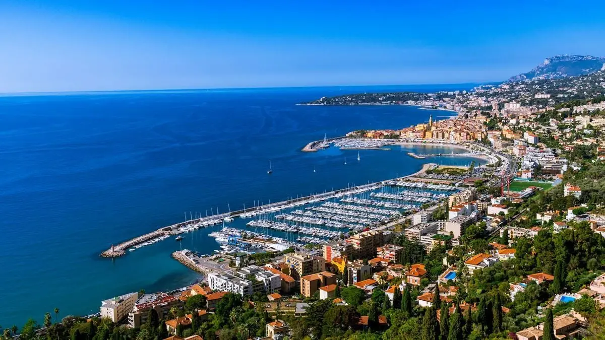 Stunning aerial view of Menton harbor, highlighting the vibrant marina and colorful coastal cityscape.