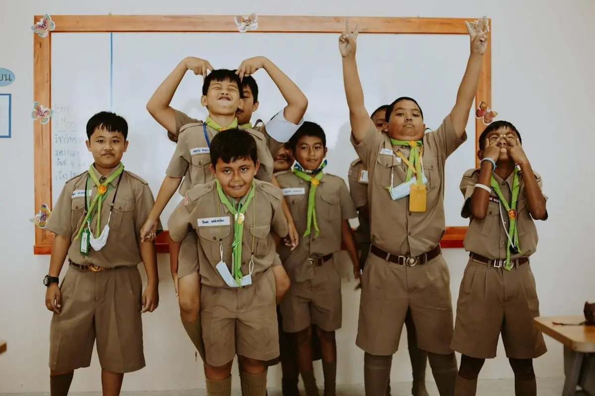 Playful school children in uniforms having fun during a classroom session.