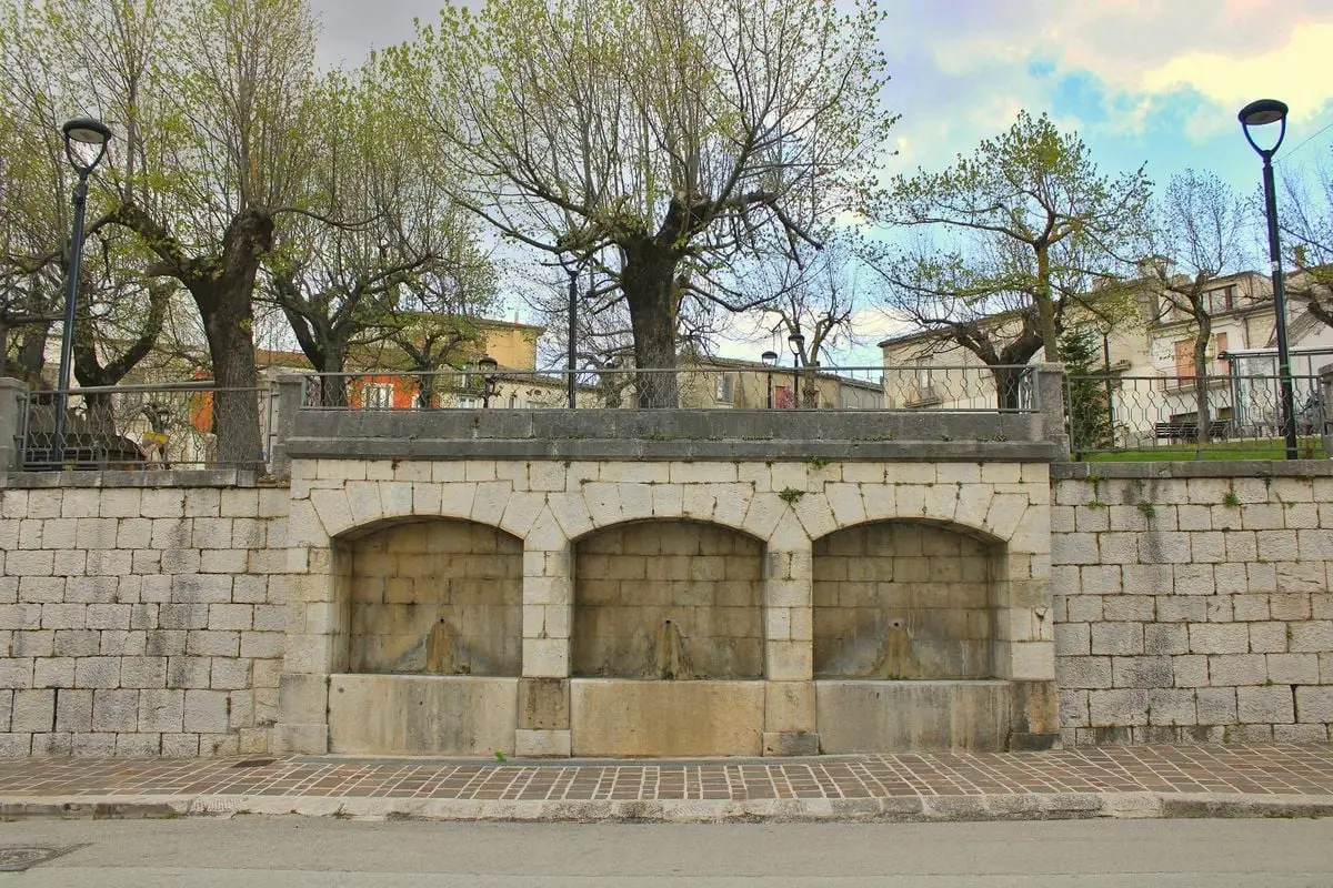 Beautiful historic stone fountain with trees in Gambatesa, Molise, Italy.