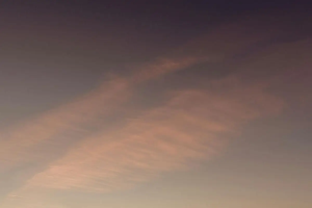 A dramatic cloudscape captured during twilight with soft, warm hues in the sky.