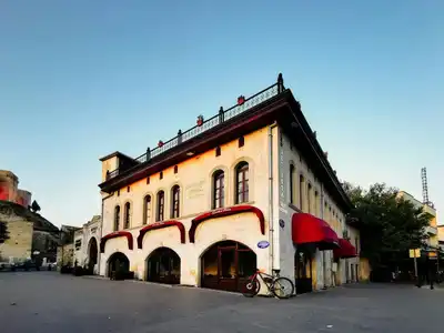 Historic building with distinct architecture and a parked bicycle under clear sky in Turkey.