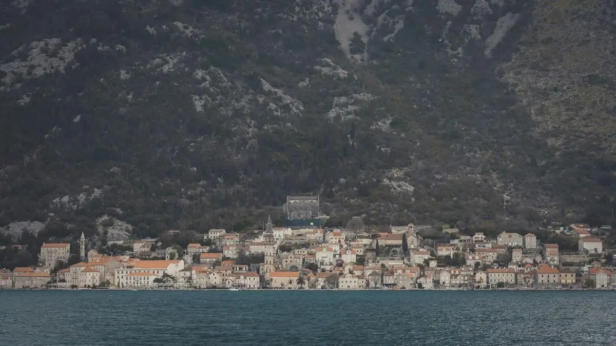 Beautiful coastal town of Kotor with rocky mountain backdrop and calm sea view.