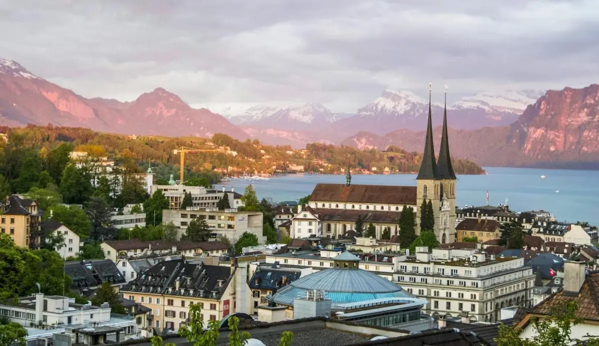 Majestic scenery of medieval city with Gothic cathedral in Alps on green seashore