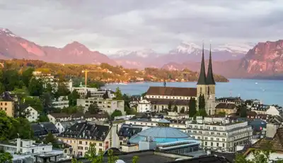 Majestic scenery of medieval city with Gothic cathedral in Alps on green seashore