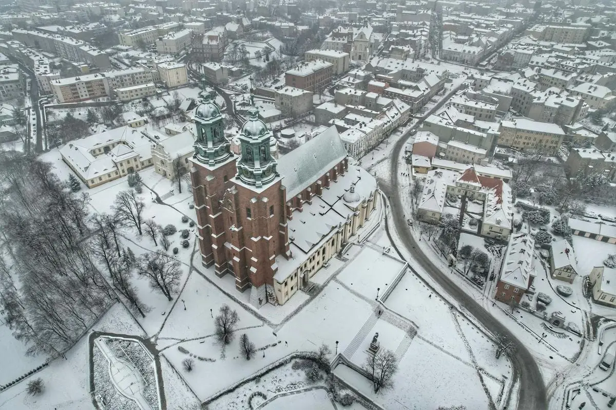 Aerial photo showcasing a snow-covered cathedral in a winter town.