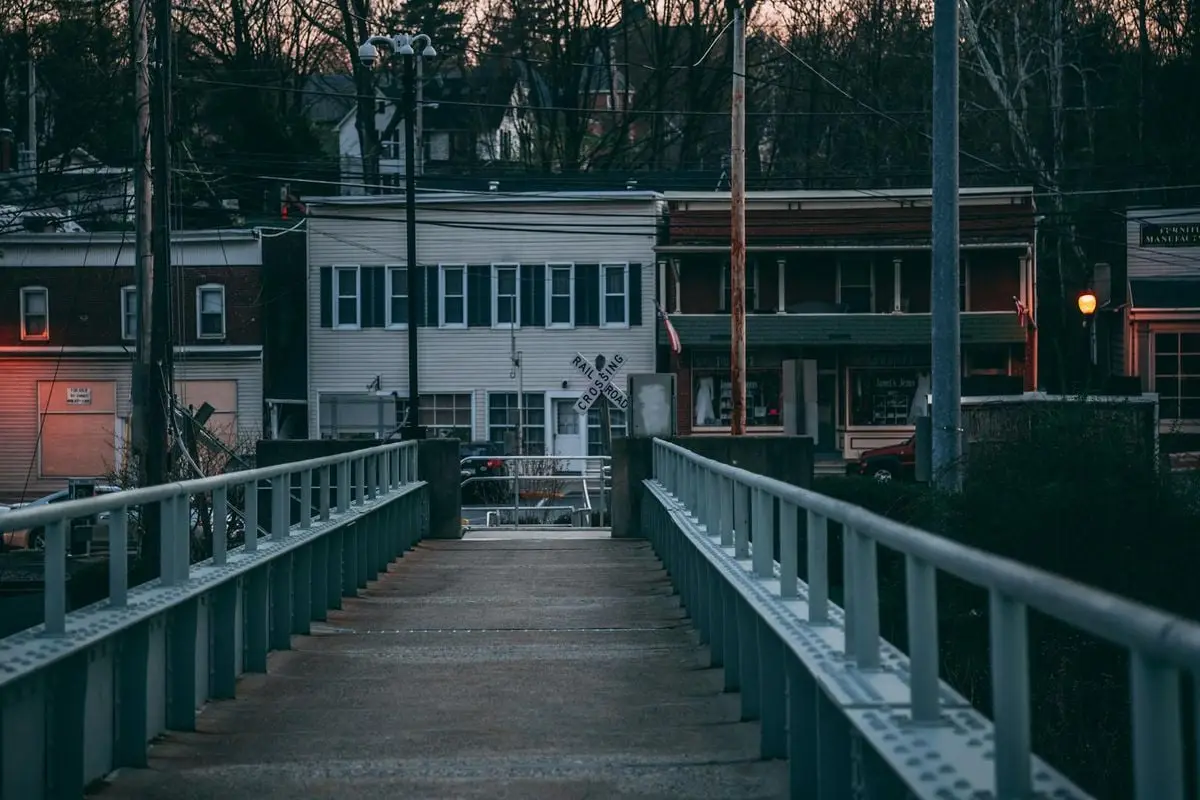 Atmospheric dusk view of a bridge leading to buildings in Portland, PA.
