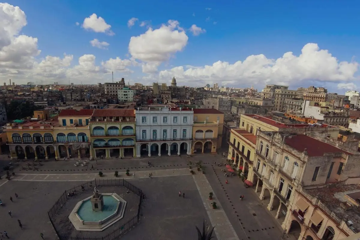 A vibrant aerial view of Old Havana's historic market square with colorful buildings and a central fountain.