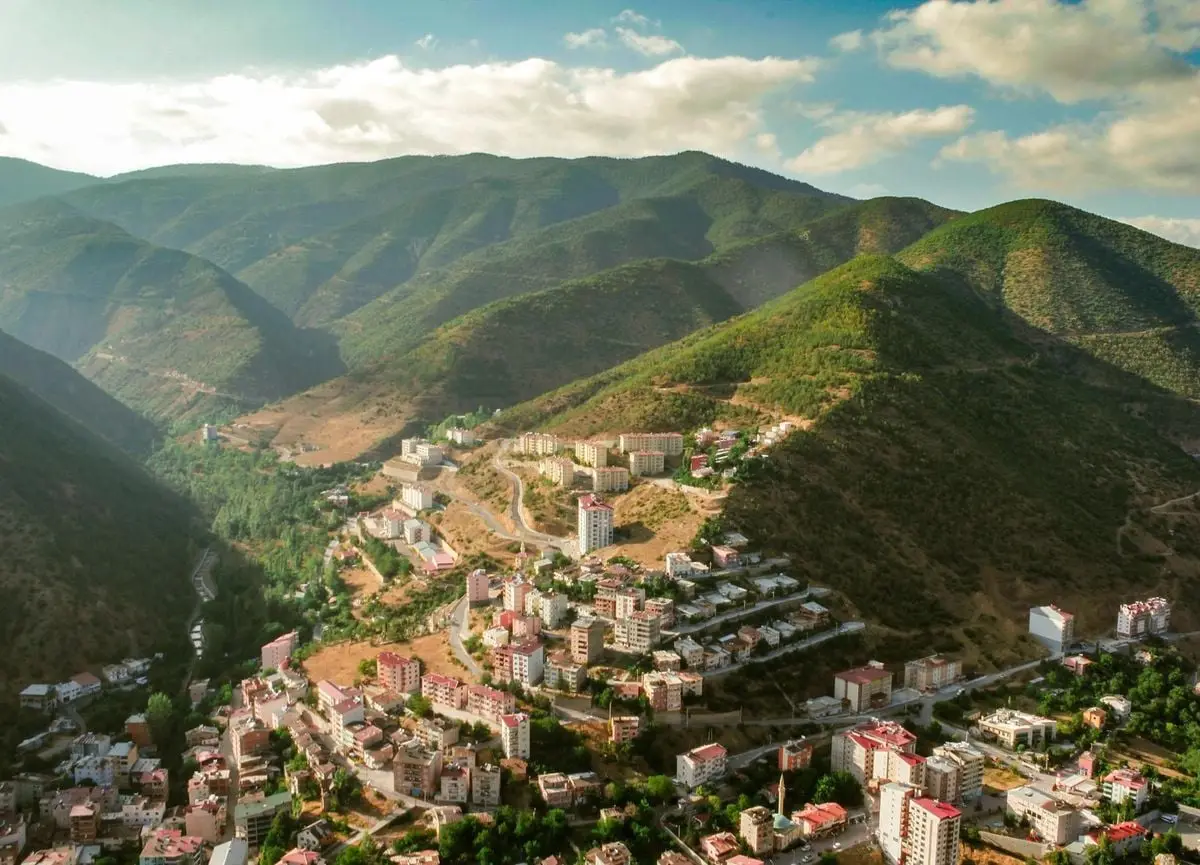 Breathtaking aerial shot of Gümüşhane city nestled among lush Turkish mountains.