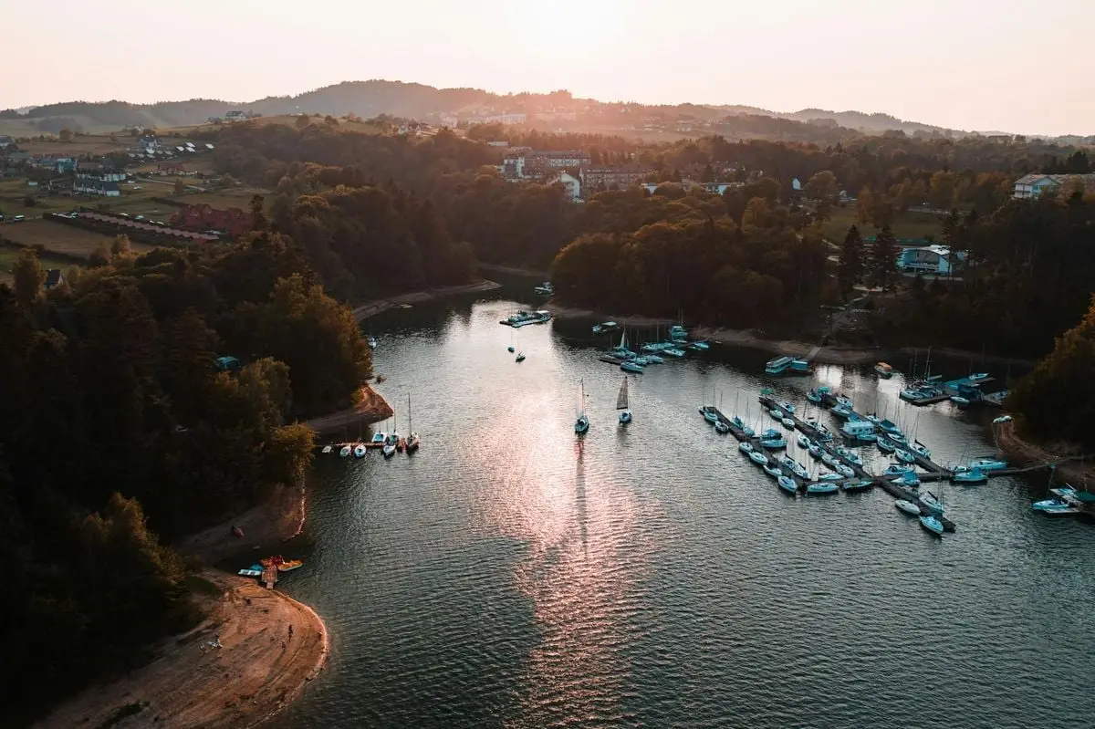 A beautiful aerial view of a peaceful marina at sunset with boats docked in calm waters.
