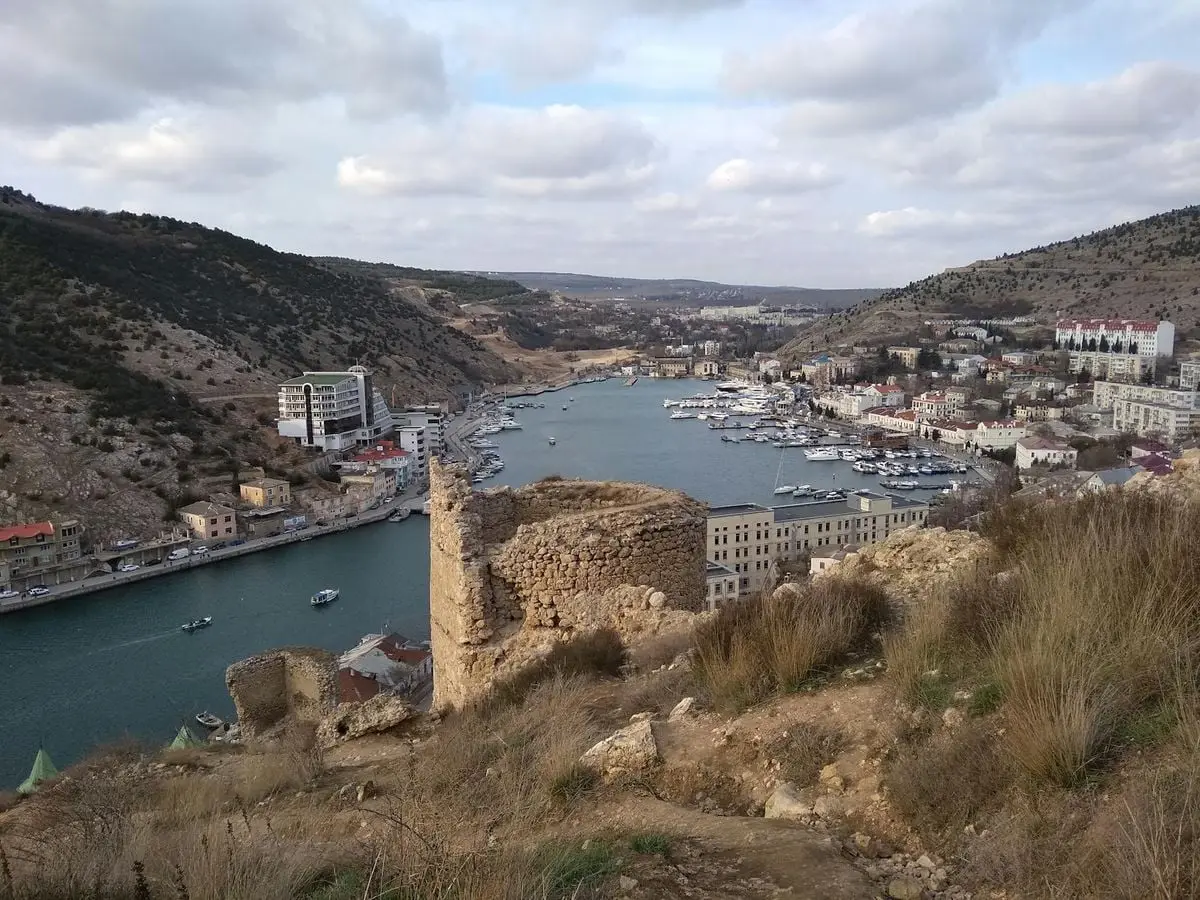 Drone shot of Sevastopol's historic harbor and ancient tower ruins on a cloudy day.