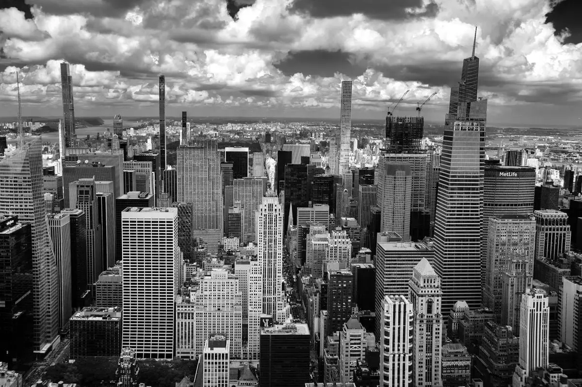 Captivating aerial view of New York City's skyline with towering skyscrapers under dramatic clouds.