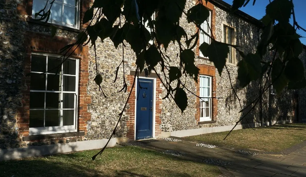 Charming old house in Norwich featuring unique flint stone walls and a striking blue door.