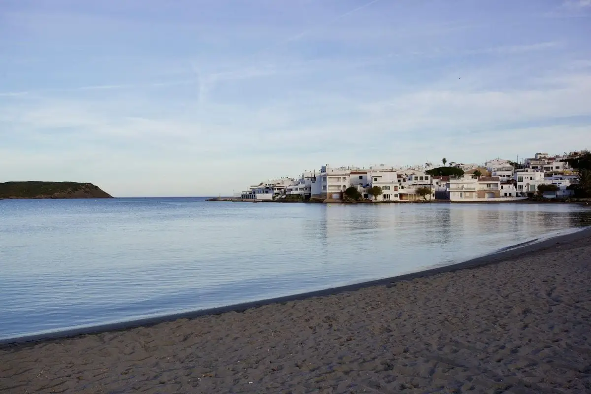 Peaceful seaside town with sandy beach and calm waters, ideal for a serene getaway.