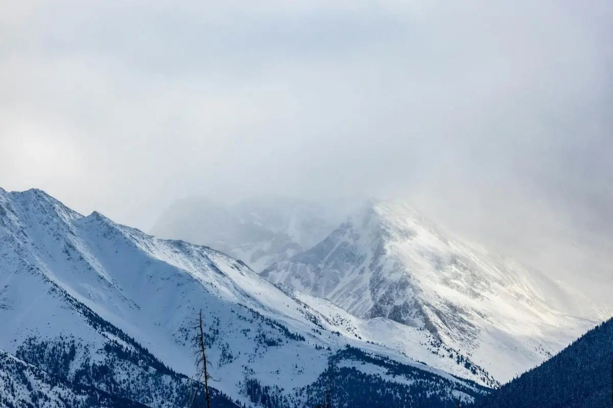 Majestic snow-covered mountains with misty peaks in Banff, Alberta.