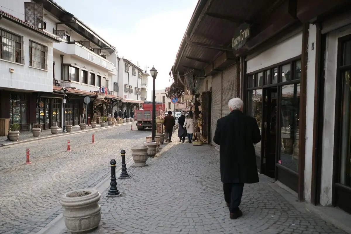 A serene cobblestone street in an old town setting, capturing everyday life with pedestrians and vintage architecture.