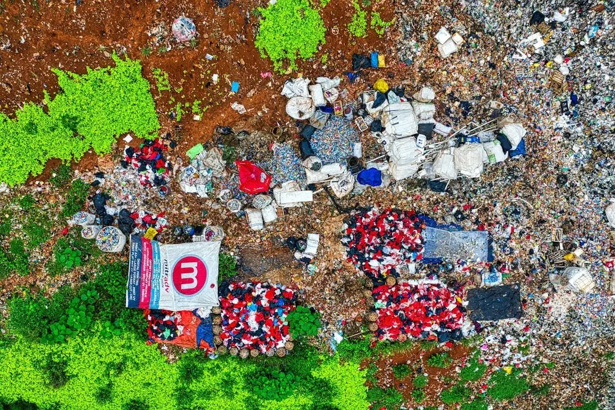 An aerial shot showing piles of waste in a dumpsite surrounded by greenery in Banten, Indonesia.