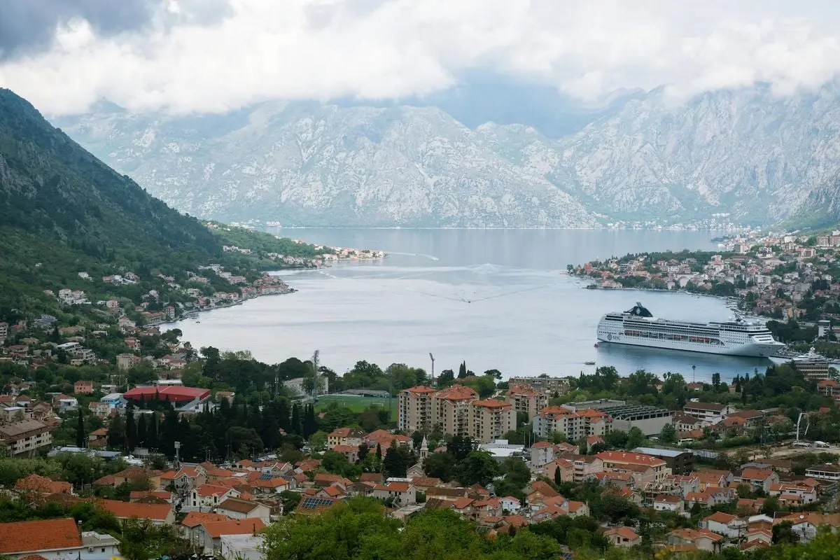 Discover the stunning landscapes of Kotor Bay, Montenegro, featuring a bustling harbor and majestic mountains.