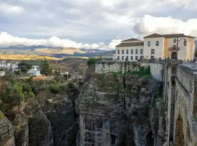 Stunning view of Ronda's cliffside architecture with dramatic landscapes and mountains in Spain.