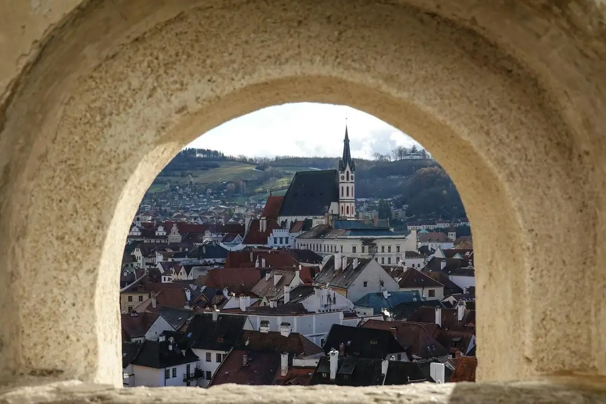 Picturesque view of Český Krumlov through a stone archway showcasing its historic charm.