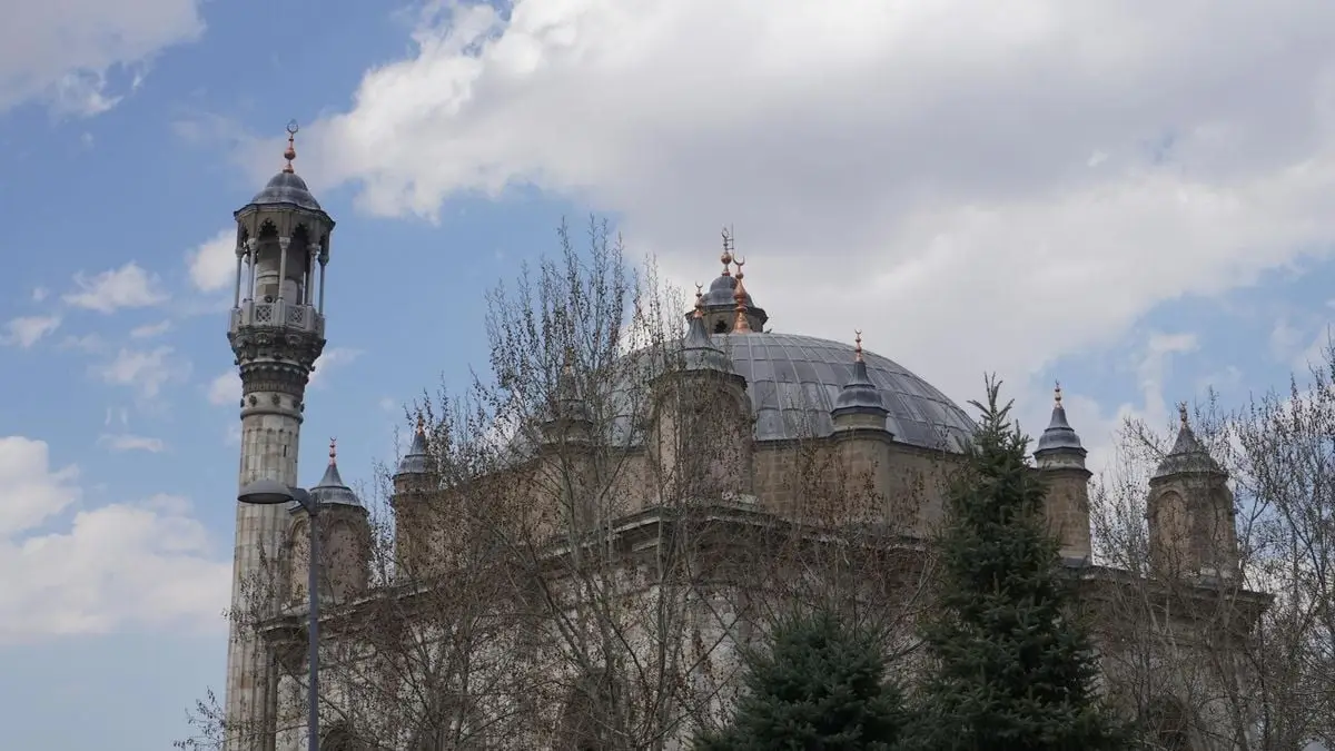 Beautiful architectural details of Aziziye Mosque under a cloudy sky in Konya, Turkey.