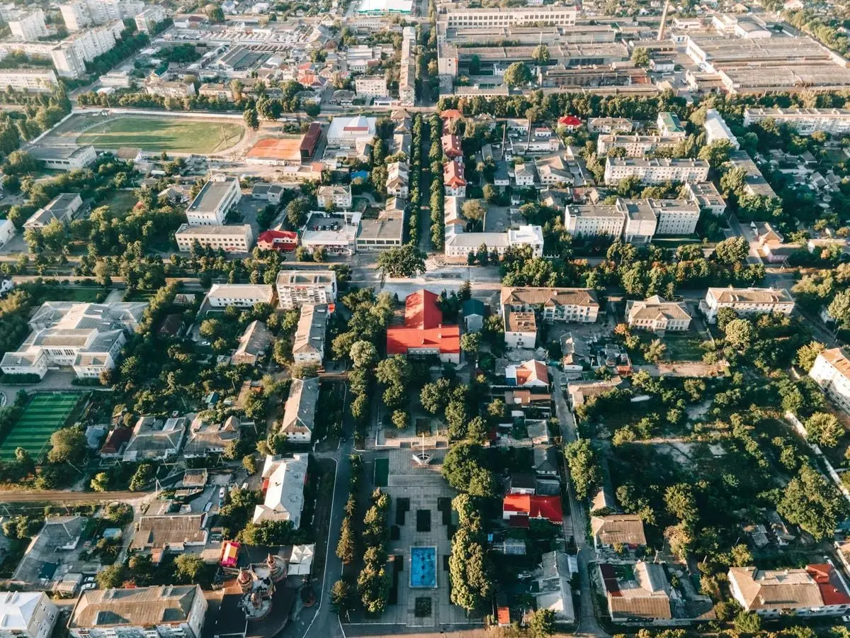 High-angle aerial view of a vibrant urban townscape with buildings and trees.