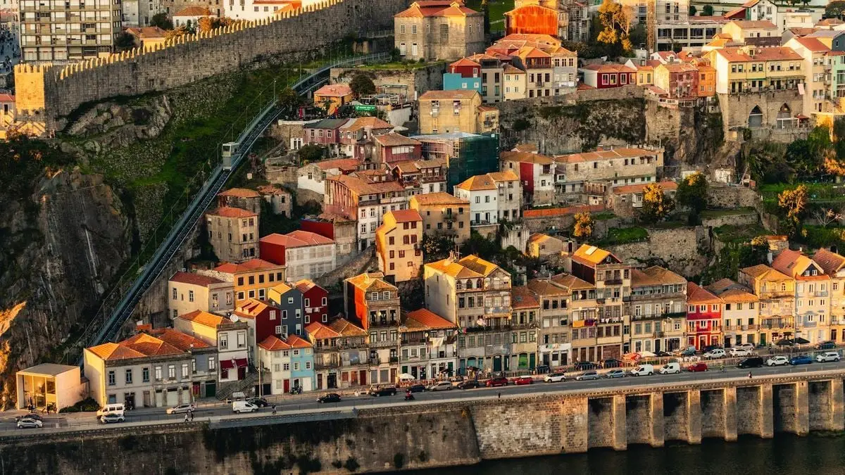 Aerial view of historic buildings on a hillside in Porto, Portugal, showcasing vibrant architecture and urban landscape.