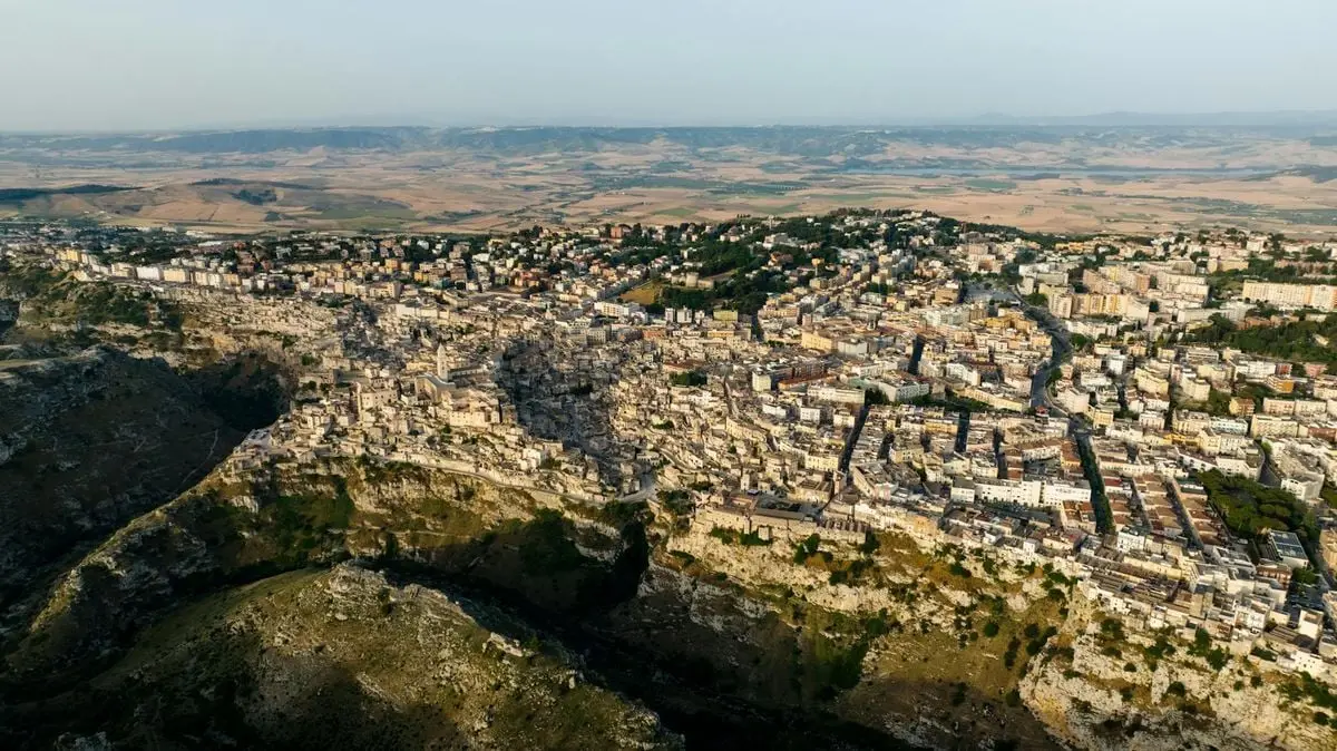 Stunning aerial view of a historic Italian town nestled among cliffs during summer.