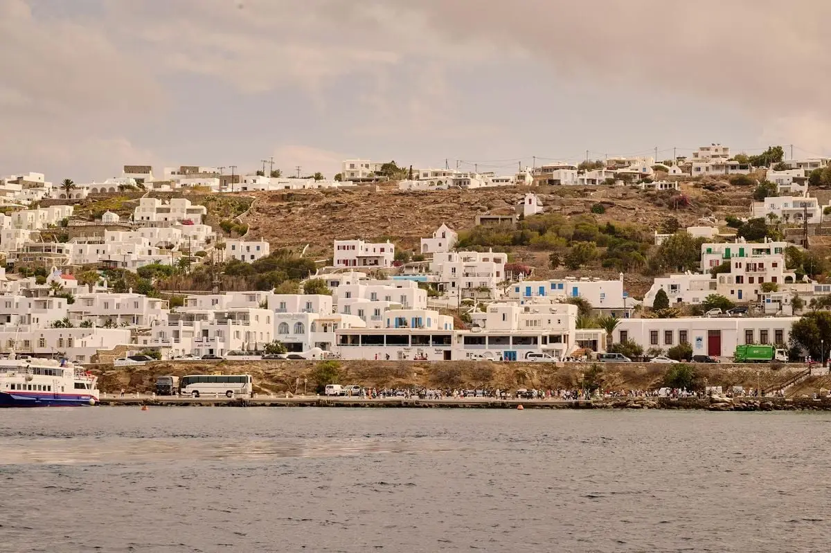Scenic view of Mykonos Island with iconic white architecture nestled on a hill by the sea.