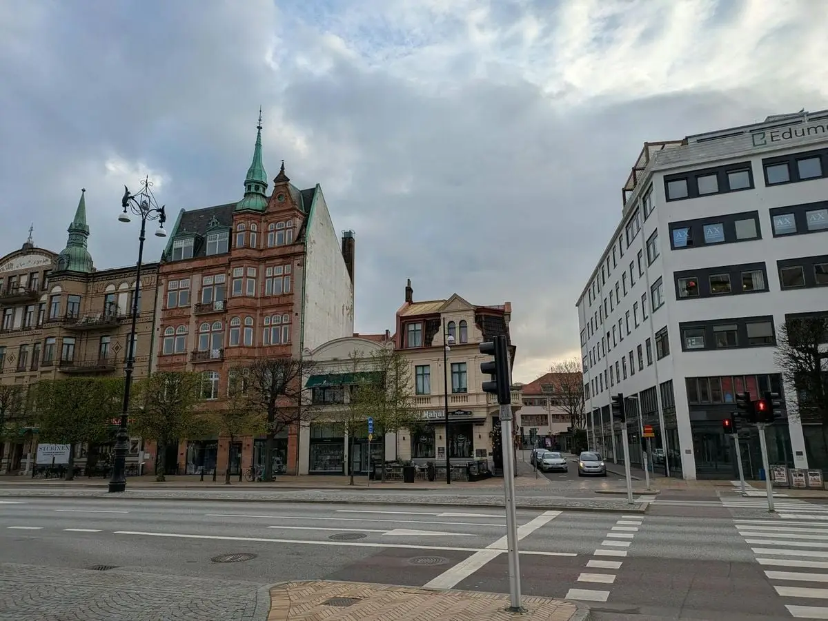 Charming street view of historic European buildings under a cloudy sky.