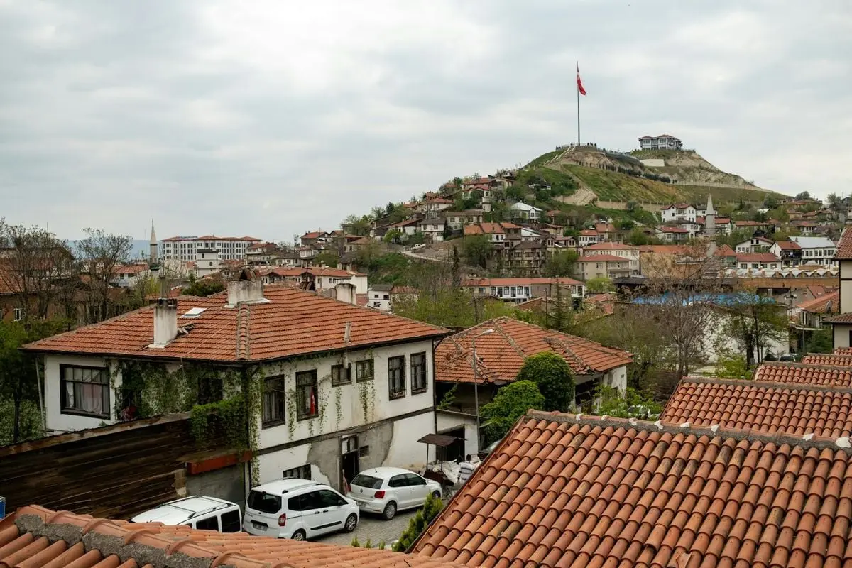 Discover the historic architecture and red-tiled roofs of Beypazarı, Ankara, with a scenic hilltop view featuring the Turkish flag.