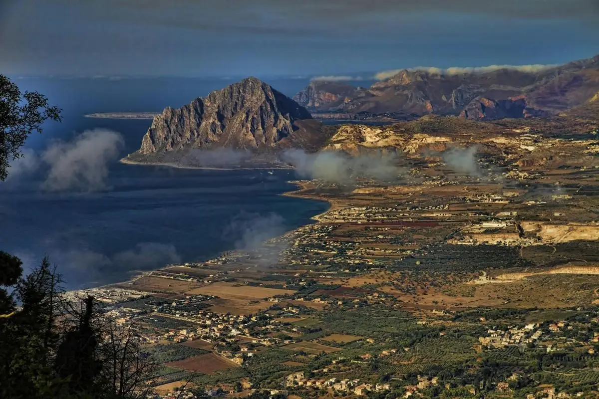 Aerial view of Monte Cofano and Sicilian coastline from Erice, capturing dramatic landscape and sea.