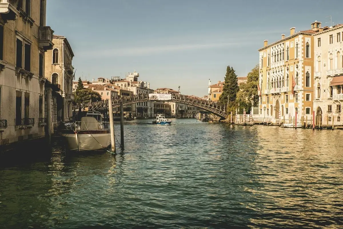 A beautiful view of the Grand Canal in Venice, featuring historic architecture and a charming bridge.