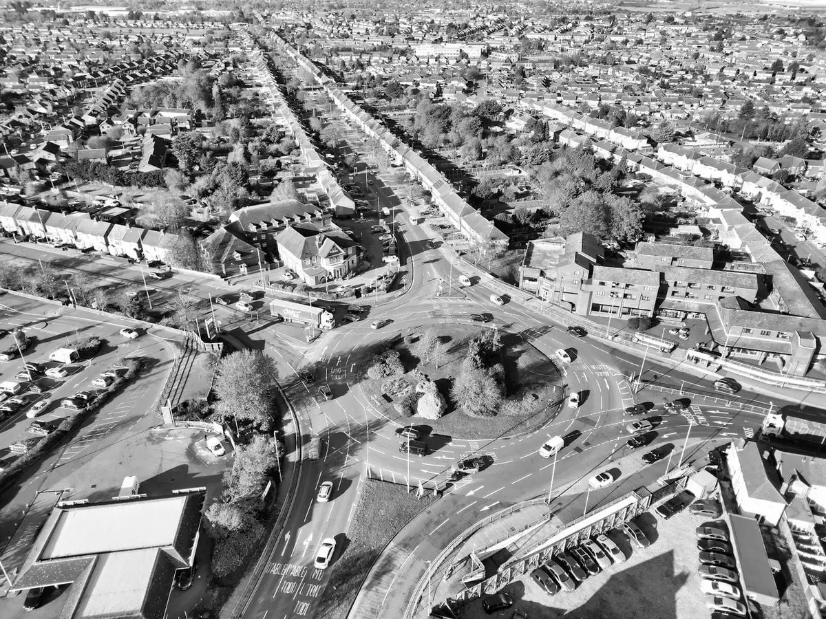 Aerial black and white view of a busy traffic circle in Luton, showcasing urban architecture.