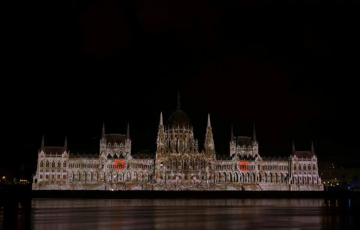 Stunning night illumination of the iconic Hungarian Parliament Building reflected in the Danube River.
