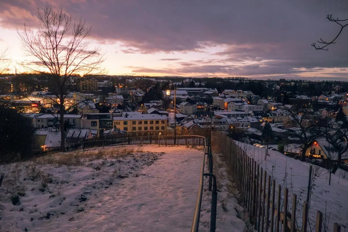 Charming small town covered in snow during twilight with a warm evening glow.