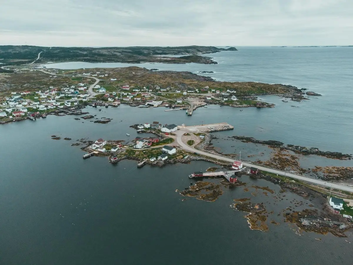 Scenic aerial view of a picturesque coastal town with harbor and surrounding landscape.