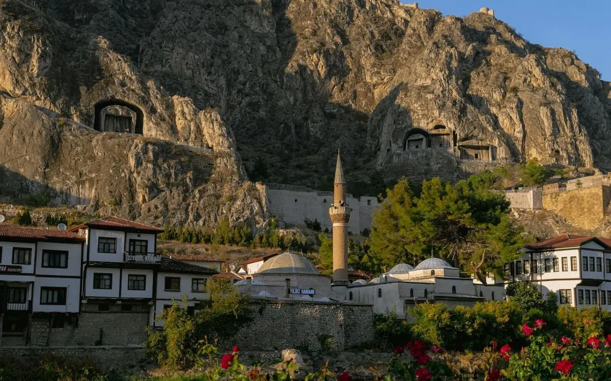 Picturesque view of Amasya, Turkey, featuring historical rock tombs and a minaret set against rugged mountains.