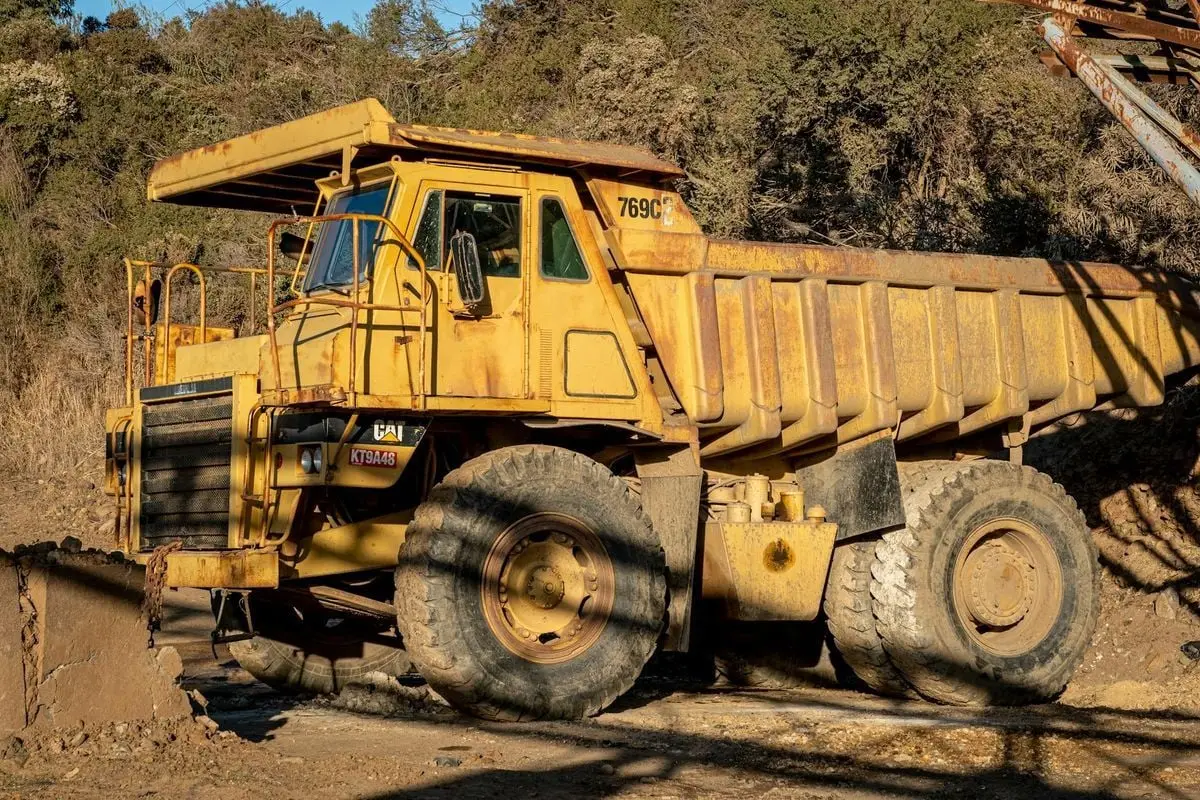 A heavy-duty dump truck on a construction site during daytime, showcasing industrial machinery in action.