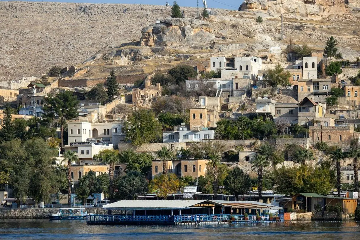 Picturesque scene of Halfeti's historic architecture by the Euphrates River under clear skies in Türkiye.