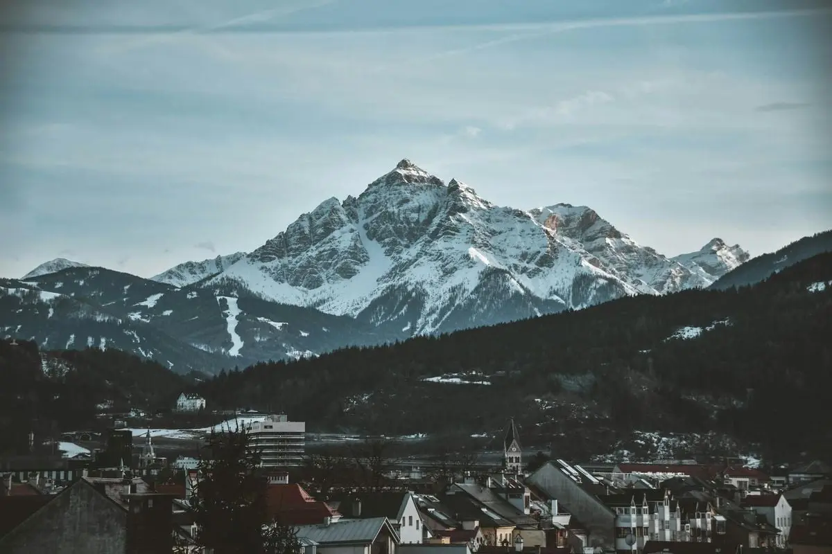 Majestic snowy mountains rise above Innsbruck, Austria, during a cold winter day.