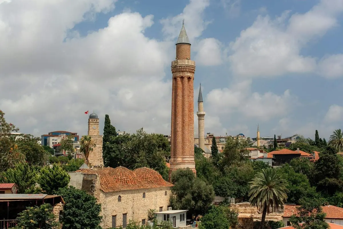 View of Yivli Minaret overlooking Antalya's old town, with surrounding architecture.