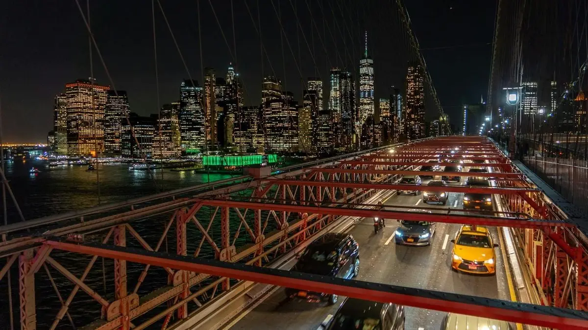 Stunning night view of Manhattan skyline and traffic on Brooklyn Bridge, New York City.