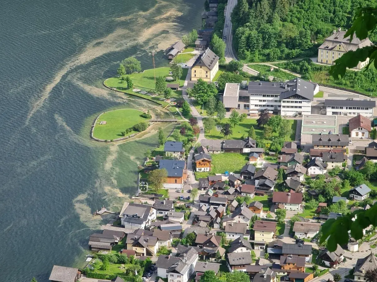 A beautiful aerial shot of a picturesque lakeside town surrounded by lush greenery in Austria.