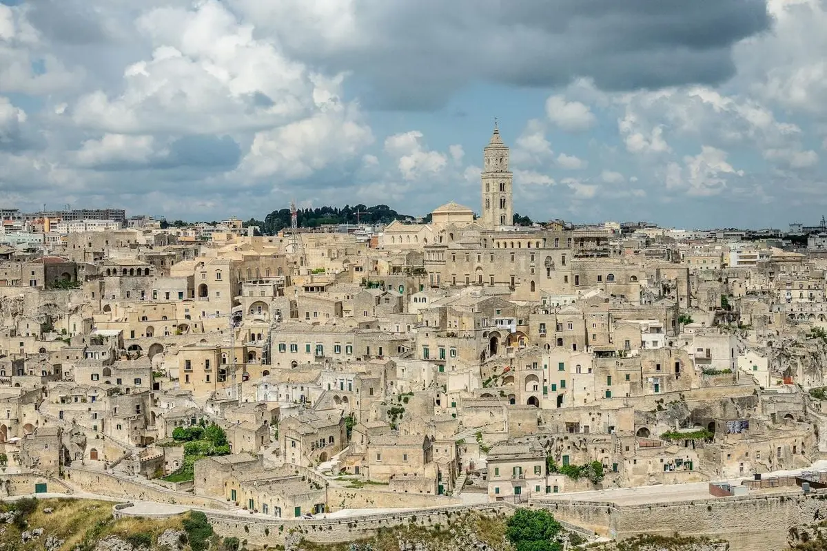 Stunning view of Matera's ancient cityscape with historic stone buildings under a cloudy sky.